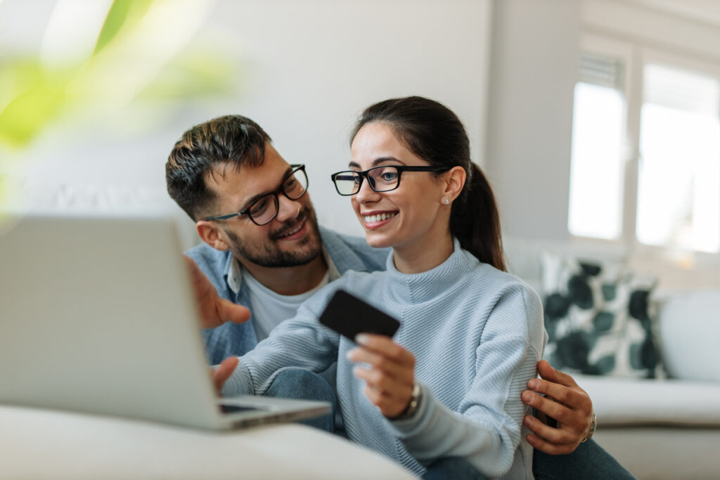 Dos socios hojeando algo para comprar con tarjeta de crédito para acumular puntos y luego acumular millas aéreas.
